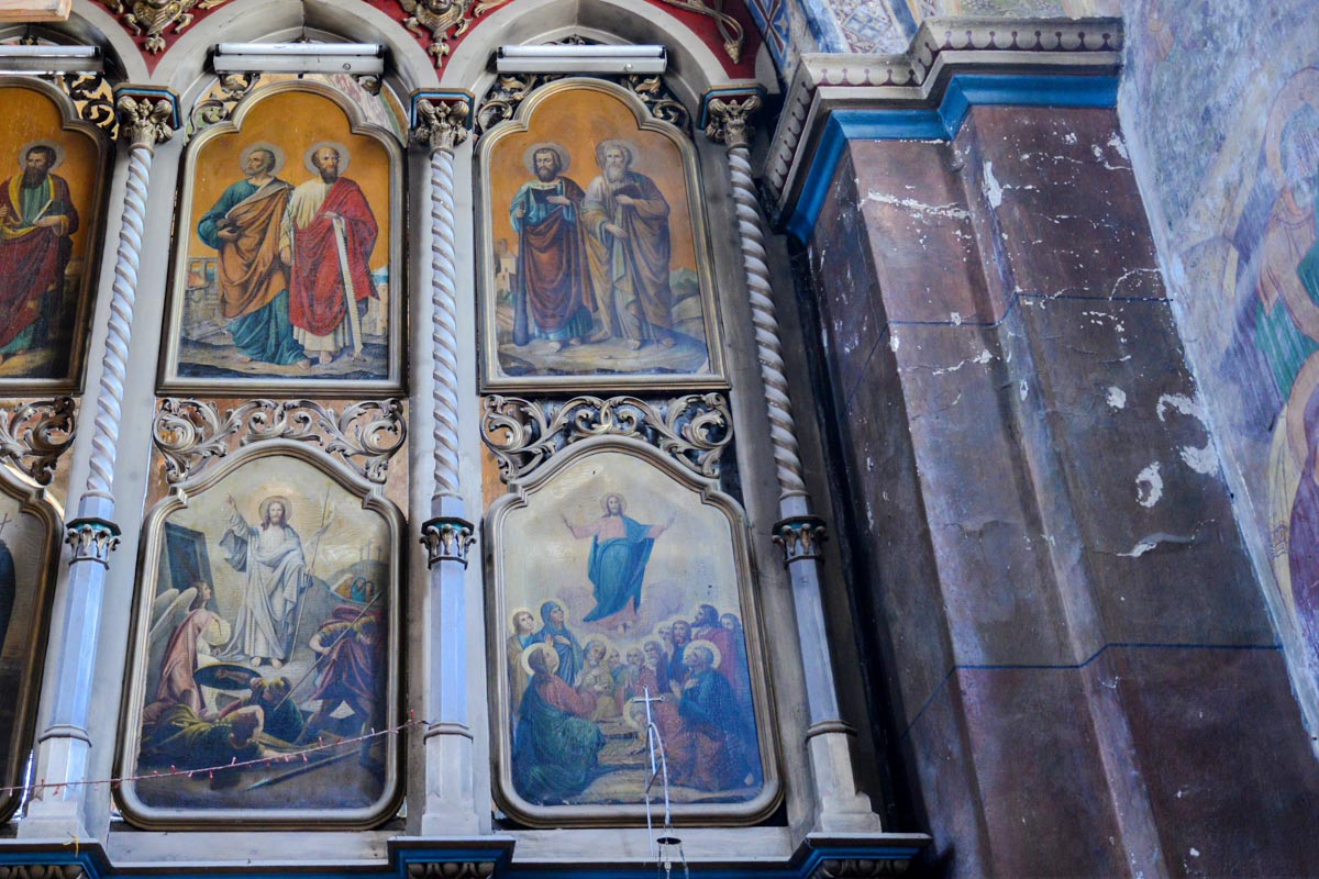 Links und rechts des Altars wird die Wand der Kirche am fröhlichen Friedhof von Săpânţa, Rumänien, von mehreren kleineren Gemälden geschmückt