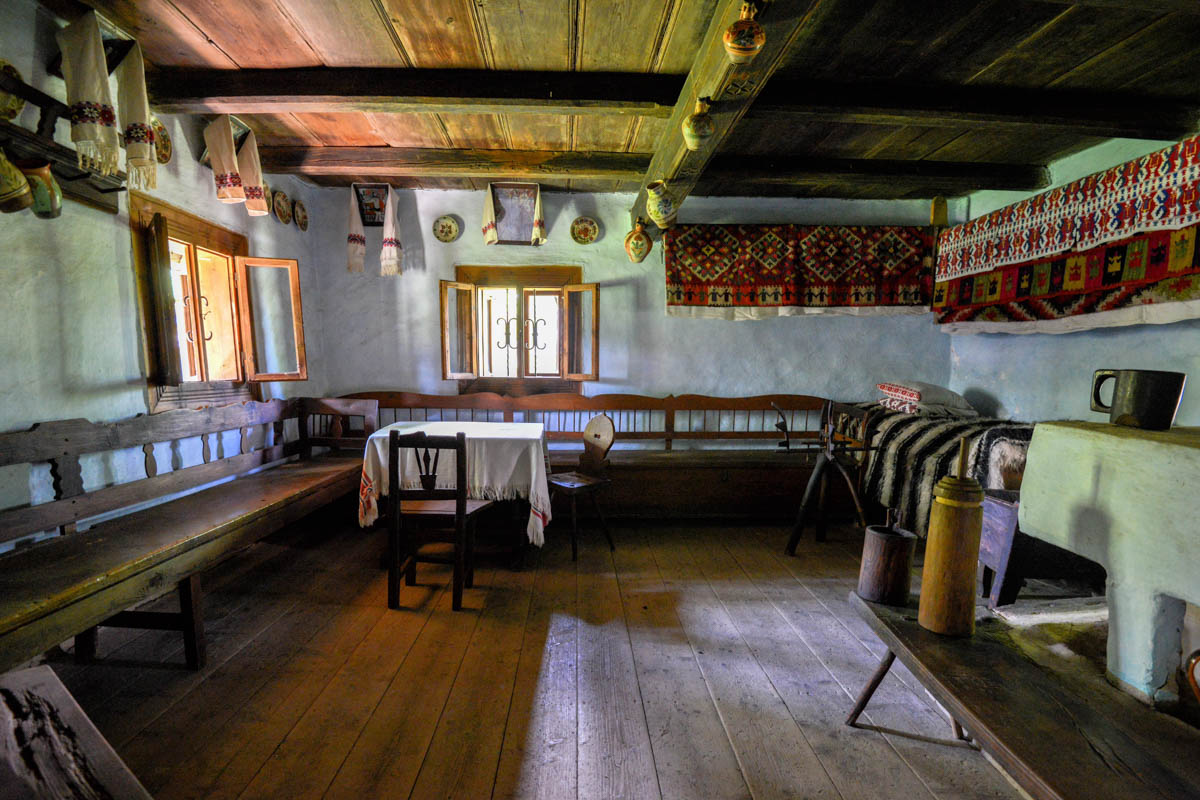 Wunderschön eingerichtet Stube in einem traditionellen Hof im Freilichtmuseum von Sighetu Marmatiei mit gekalkten Wänden und Holzfußboden, Rumänien