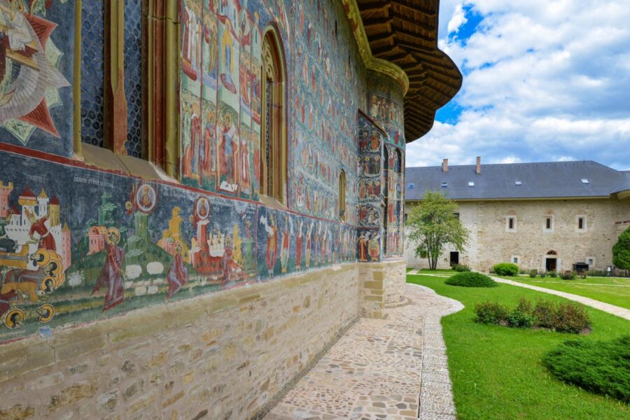 Mit dem Grün des Gartens und dem Blau des Himmels ergibt der Bilderteppich auf der Kirchenfassade von Sucevița ein überwältigendes Fotomotiv, Rumänien - © FRASHO / franks-travelbox