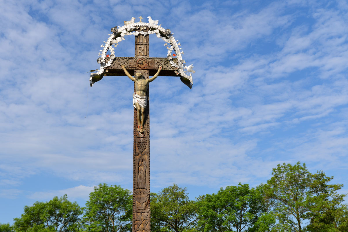 Holzkreuz vor dem Eingang der eindrucksvollen Holzkirche von Șurdești in Rumänien
